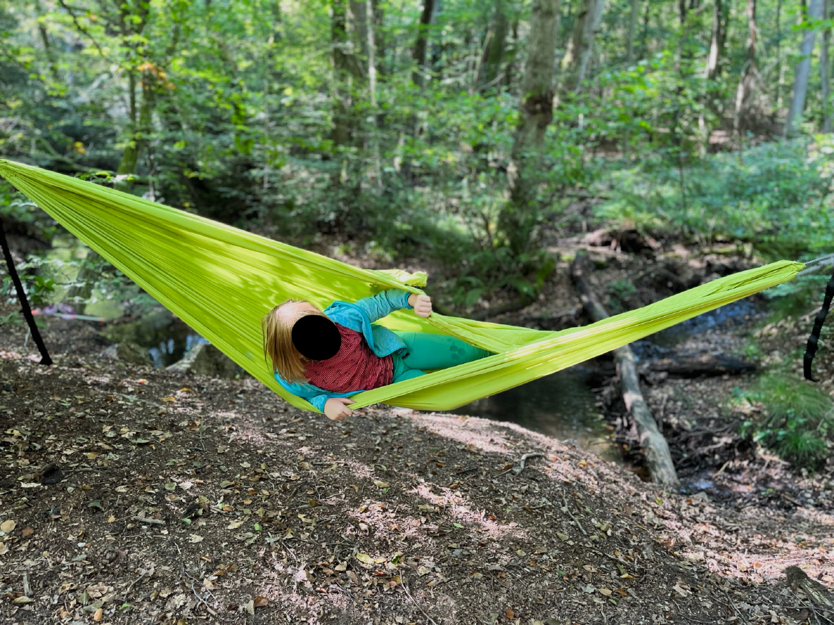Kind in Hängematte im Wald