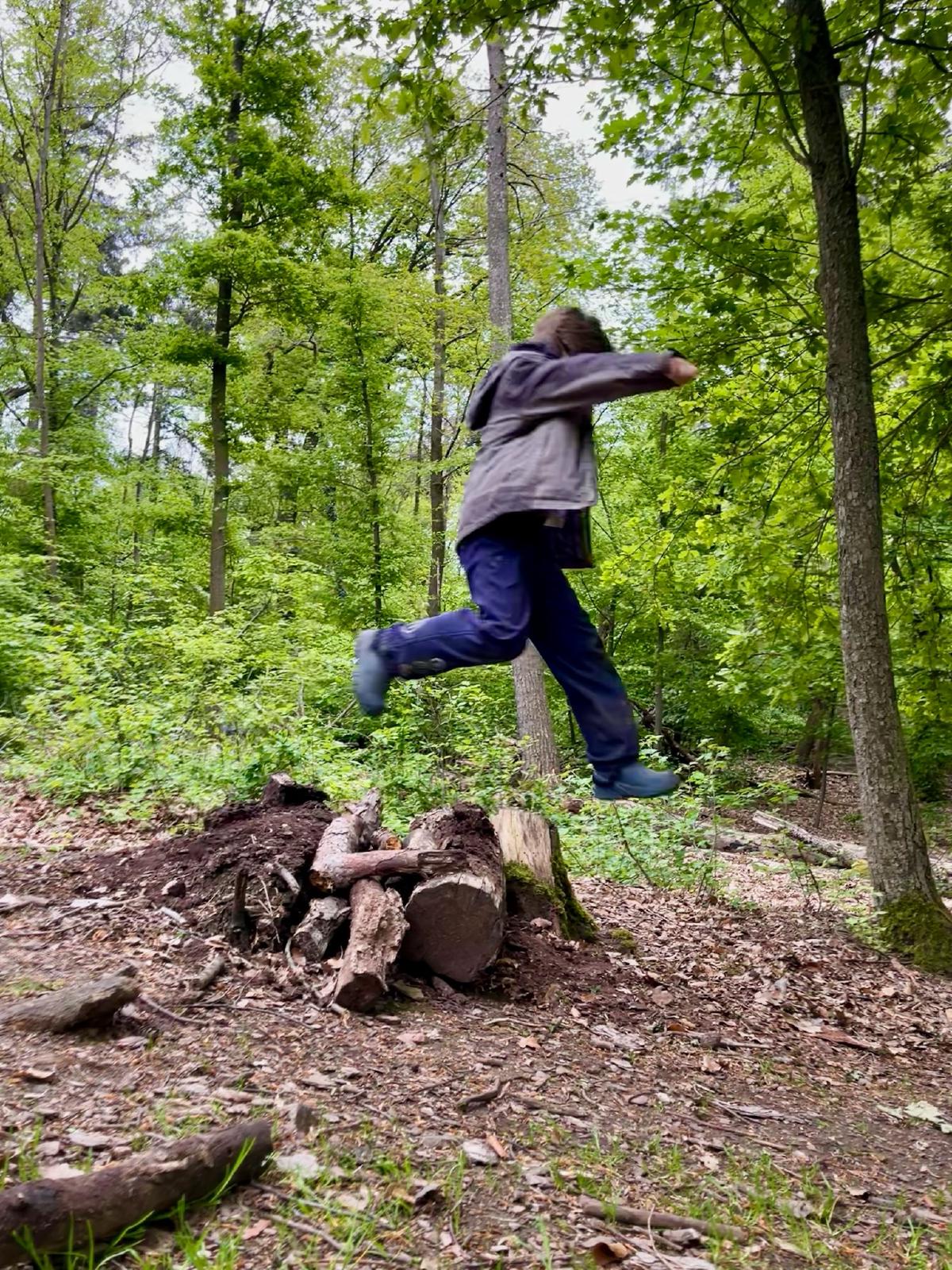 Kind springt im Wald